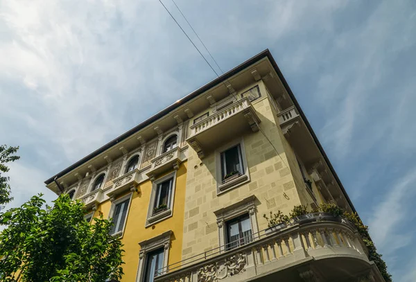 Pulserande Medelhavet färgglada gula byggnaden fasad och balkong i Milano, Lombardiet, Italien — Stockfoto