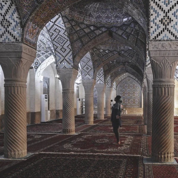 Una mujer con un pañuelo en la cabeza reza en la mezquita Nasir Al-Mulk en Shiraz, Irán, también conocida como Mezquita Rosa — Foto de Stock