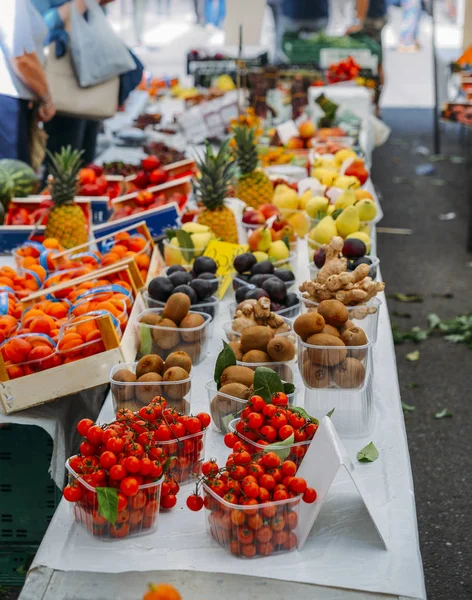 Fileiras de frutas frescas à venda em uma tenda de mercado - foco seletivo em tomates em primeiro plano . — Fotografia de Stock