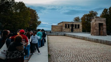 İspanya 'nın Madrid kentinde yeniden inşa edilen antik bir Mısır tapınağı olan Debod Tapınağı' na girmek için kuyruğa giren turistler görülüyor.