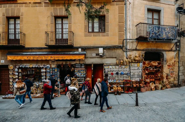 Los turistas caminan por una calle llena de tiendas de recuerdos en el centro histórico de Segovia, España — Foto de Stock