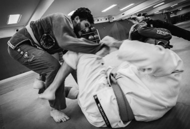 İki genç adam Brezilya Jiu-Jitsu idmanı yapıyor, bir kimono giyle yakalama sanatı - Sahnelenmemiş İçerik veya Kapalı Etkinlik
