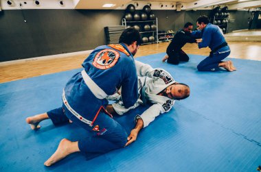 İki genç adam Brezilya Jiu-Jitsu idmanı yapıyor, bir kimono giyle yakalama sanatı - Sahnelenmemiş İçerik veya Kapalı Etkinlik