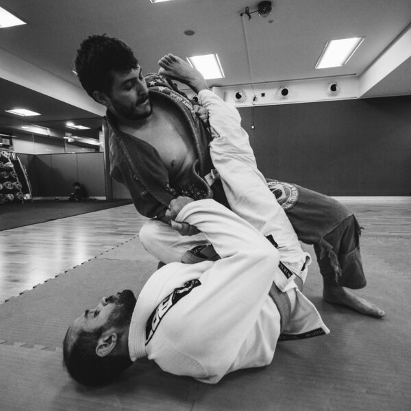 Two young men practice Brazilian Jiu-Jitsu sparring, a grappling type martial arts with a kimono gi - NOT STAGED CONTENT OR AT CLOSED EVENT