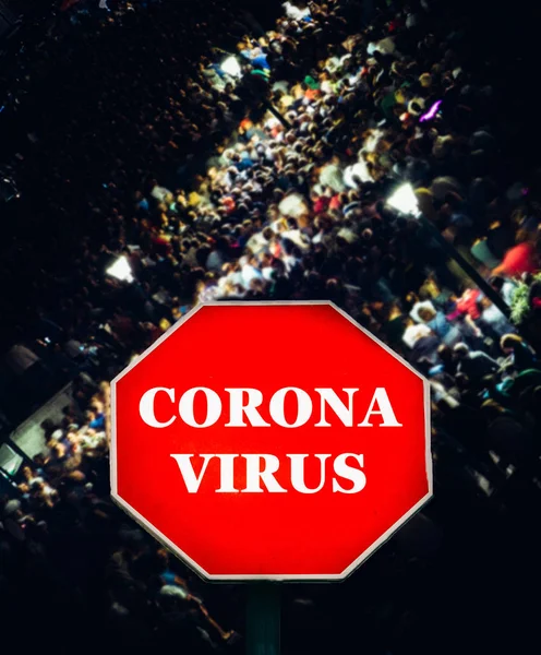 Coronavirus stop sign with large group of unidentifitable people in background - epidemic close proximity virus transmission — Stock Photo, Image