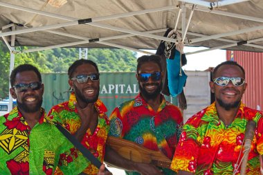 Port Vila, Vanuatu - February 14, 2020: Kanak men in colourful shirts singing and posing for tourists. clipart