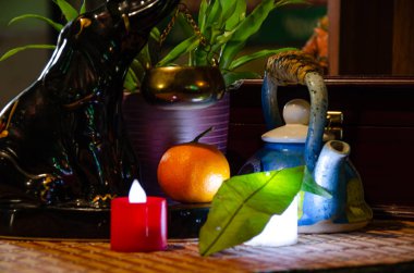 Şenlikli bir akşamdı. Porselen Seylan fili, seramik çaydanlık, iki dekoratif mum, mandalina..