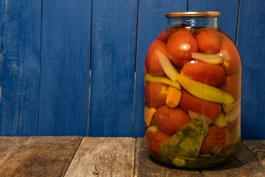 Konserve ürünleri, ekjika, ahşap arka planda domates. Kış için ürün toplama ve depolama.