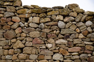 Taştan yapılmış eski kalenin duvarı. Eski bir taşın arkaplanı.