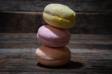 Tahta bir masadaki piramide istiflenmiş makarna kekleri..