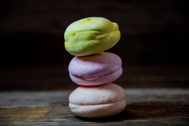 Tahta bir masadaki piramide istiflenmiş makarna kekleri..