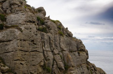 Dağ deniz manzarası. Deniz kıyısındaki büyük desenli kaya. Seyahat ve macera.