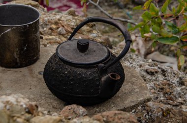 Dağlarda eski toprak, işlenmiş demir çaydanlık. Seyahat ve macera.