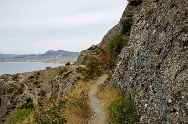 在通往大海的大石头和悬崖之间的山路 — 图库照片