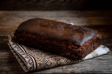 Mutfak peçetesinde, ahşap arka planda ev yapımı köy ekmeği. Mutfakta yemek pişirmek..