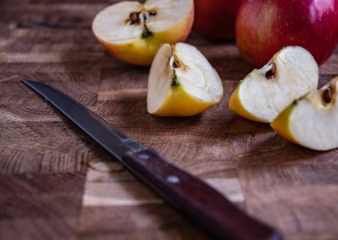 Mutfak tahtasında dilimlenmiş elma ve bıçak..