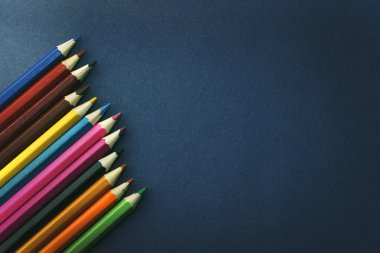 İzole mavi arka plan üzerinde renkli kalemler