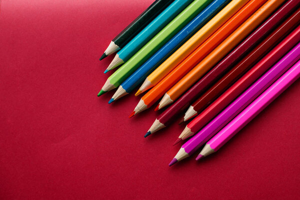 Coloured pencils isolated on the red background