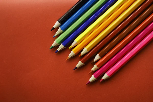 Zole Kırmızı Arka Plan Üzerinde Renkli Kalemler — Stok fotoğraf