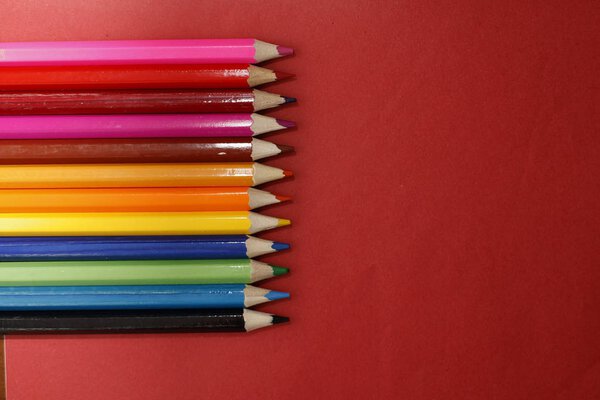 Coloured pencils isolated on the red background