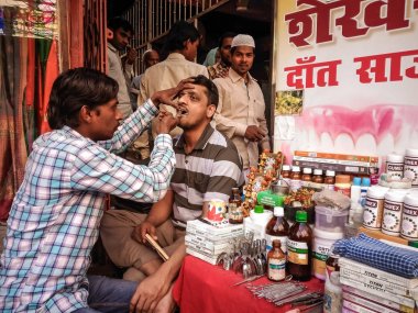 Varanasi, Hindistan - Mart, 16, 2016. Sokak diş hekimi ve Varanasi sokaklarında hastasına