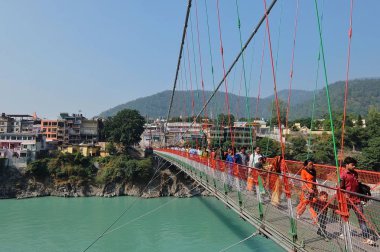 Rishikesh, Hindistan - Kasım, 5, 2017. Güzel manzara Rishikesh Ganga nehir set of. RAM Jhula köprüyü geçtikten insanlar