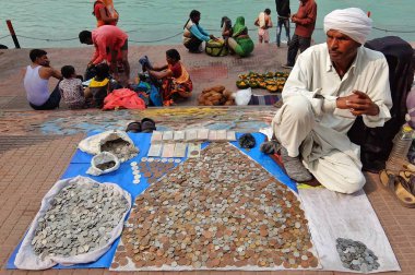 Harid, Hindistan - Kasım, 6, 2017. Eski sikkeler Haridwar Ganga nehire nehir üzerinde satan adam.