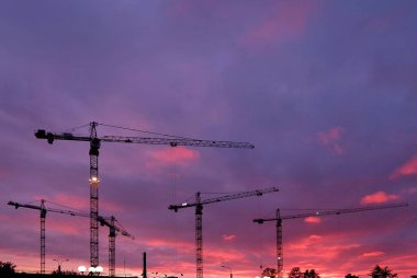 İnşaat ile endüstriyel arka plan siluetleri üzerinde şaşırtıcı günbatımı gökyüzü vinç