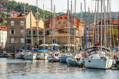 Muggia, İtalya - Ağustos 2018. Limanda güneşli bir gün. Küçük bir sahil kasabası olan Muggia 'da demirlemiş yatların manzarası..