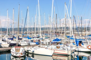Muggia, İtalya - Ağustos 2018. Limanda güneşli bir gün. Küçük bir sahil kasabası olan Muggia 'da demirlemiş yatların manzarası..