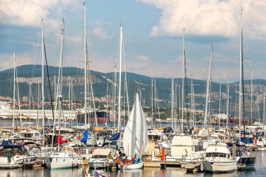 Muggia, İtalya - Ağustos 2018. Limanda güneşli bir gün. Küçük bir sahil kasabası olan Muggia 'da demirlemiş yatların manzarası..