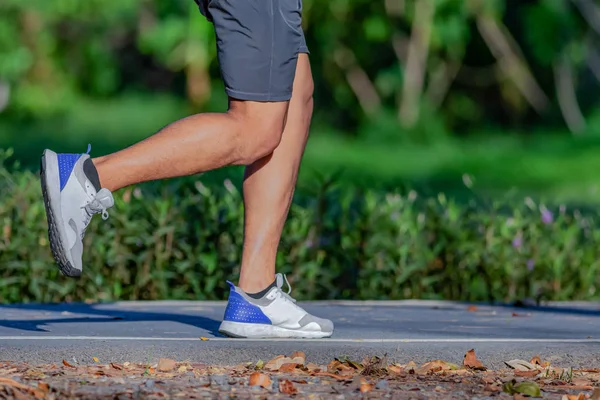 A man and a  woman are jogging in the evening on the public park