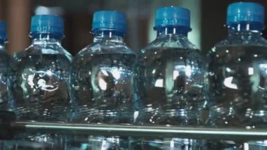 plastik şişe su dolu üretim hattı üzerinde mavi bir kap ile