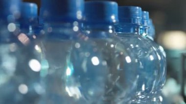 plastik şişe su dolu üretim hattı üzerinde mavi bir kap ile