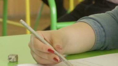bir kızın kırmızı-çivi ile el bir grafit kalem tutan ve test yazmaya başlar