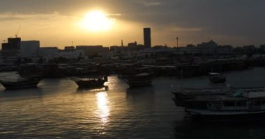 Katar 'da gün batımında limandaki sularda turist tekneleri.