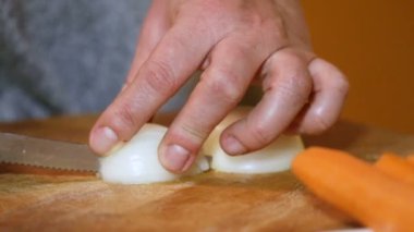 Kadın soğanları yavaş çekimde doğruyor. Havuçla. Yakın çekim.