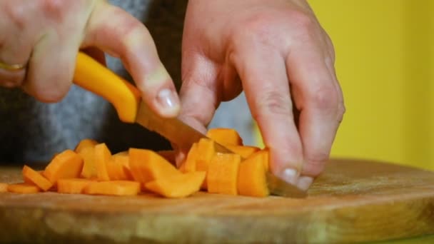 Samičí Ruce Oranžovým Nožem Rozsekat Mrkev Kousky Dřevěné Desce Zpomaleném — Stock video