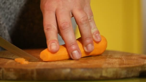 Samičí Ruce Oranžovým Nožem Rozsekat Mrkev Kousky Dřevěné Desce Zpomaleném — Stock video