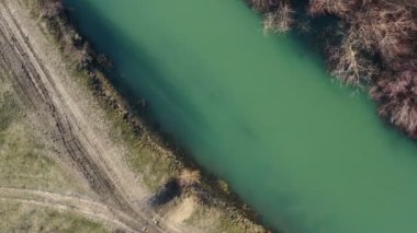Sahilleri olan yeşil nehrin üst manzarası. İHA tarafından havadan çekilen dairesel hareket. ve aşağı iniyor