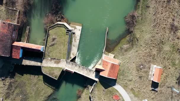 一座小河流上的大坝的俯瞰 无人驾驶飞机上的子弹向下移动 绕了个圈 — 图库视频影像