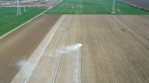 Fliegen Hinter Einem Traktor Der Einem Windigen Frühlingstag Mit Chemikalien — Stockvideo