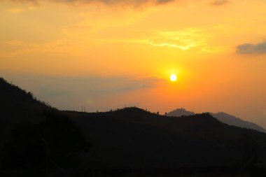 Dağların ve vadilerin üzerinde yoğunlaşmamış arka planda renkli günbatımı gökyüzü