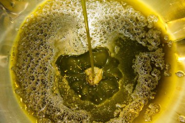 Yunanistan 'daki zeytinyağı fabrikasındaki çıkartma işlemi sırasında, inoks kabının dibinde ekstra saf zeytinyağı.