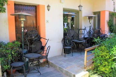 Atina, Yunanistan, 6 Mayıs 2020 - Coronavirus tecridi sırasında kapalı kafe restoranının önünde masa ve sandalyeler yığıldı.
