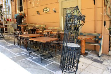 Atina, Yunanistan, 6 Mayıs 2020 - Coronavirus tecridi sırasında kapalı kafe restoranının önünde masa ve sandalyeler yığıldı.