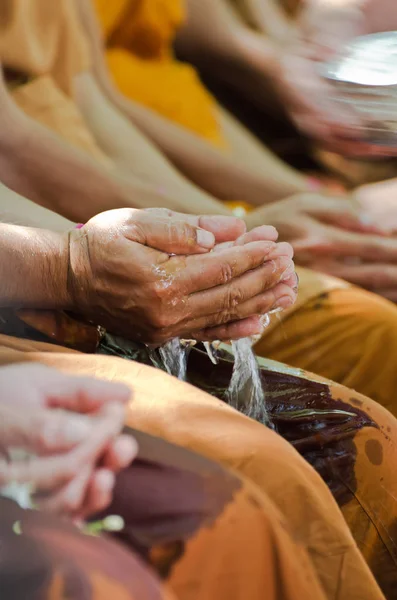 Menschen feiern Songkran, indem sie Mönchen Wasser in die Hand schütten — Stockfoto