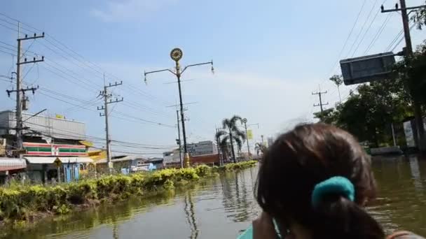 Неопознанная женщина использует лодку в качестве транспорта на дороге Пхуттамонтон Сай 4 во время наихудшего наводнения — стоковое видео