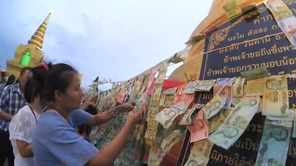 Pessoas não identificadas pendurar oferta de dinheiro em linha em torno stupa dourado — Vídeo de Stock