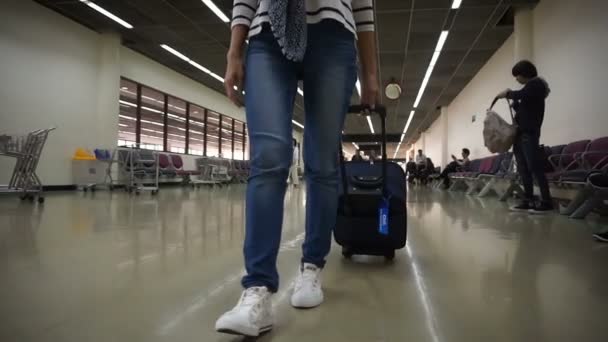 Mujer con bolsa de carro caminando lentamente en la terminal del aeropuerto — Vídeo de stock